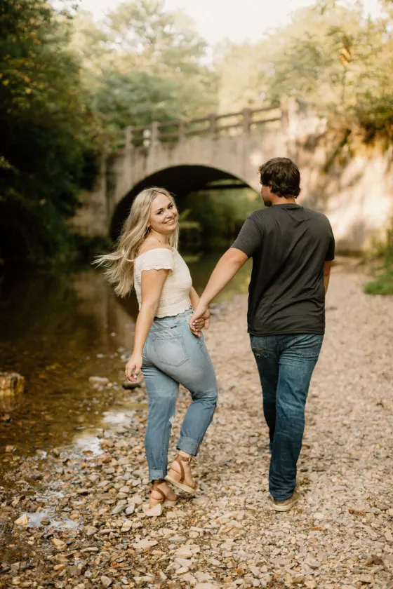 Couple holding hands near a bridge