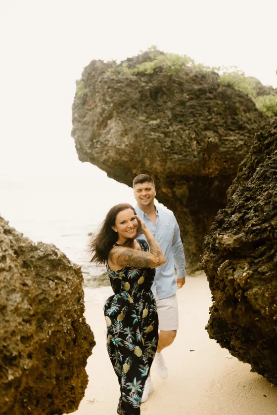 Couple walking between beach rocks