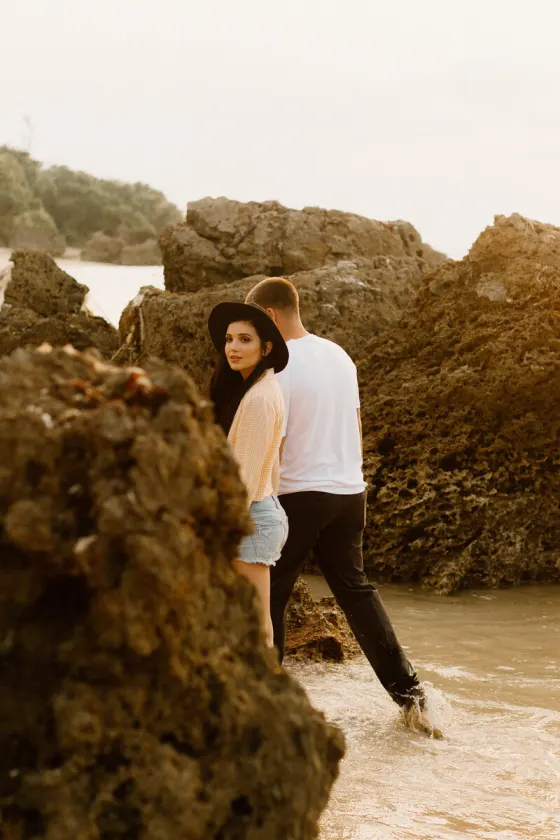 Couple standing together by coastal rocks