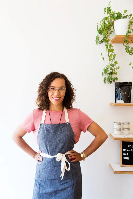 A smiling shop owner wearing an apron